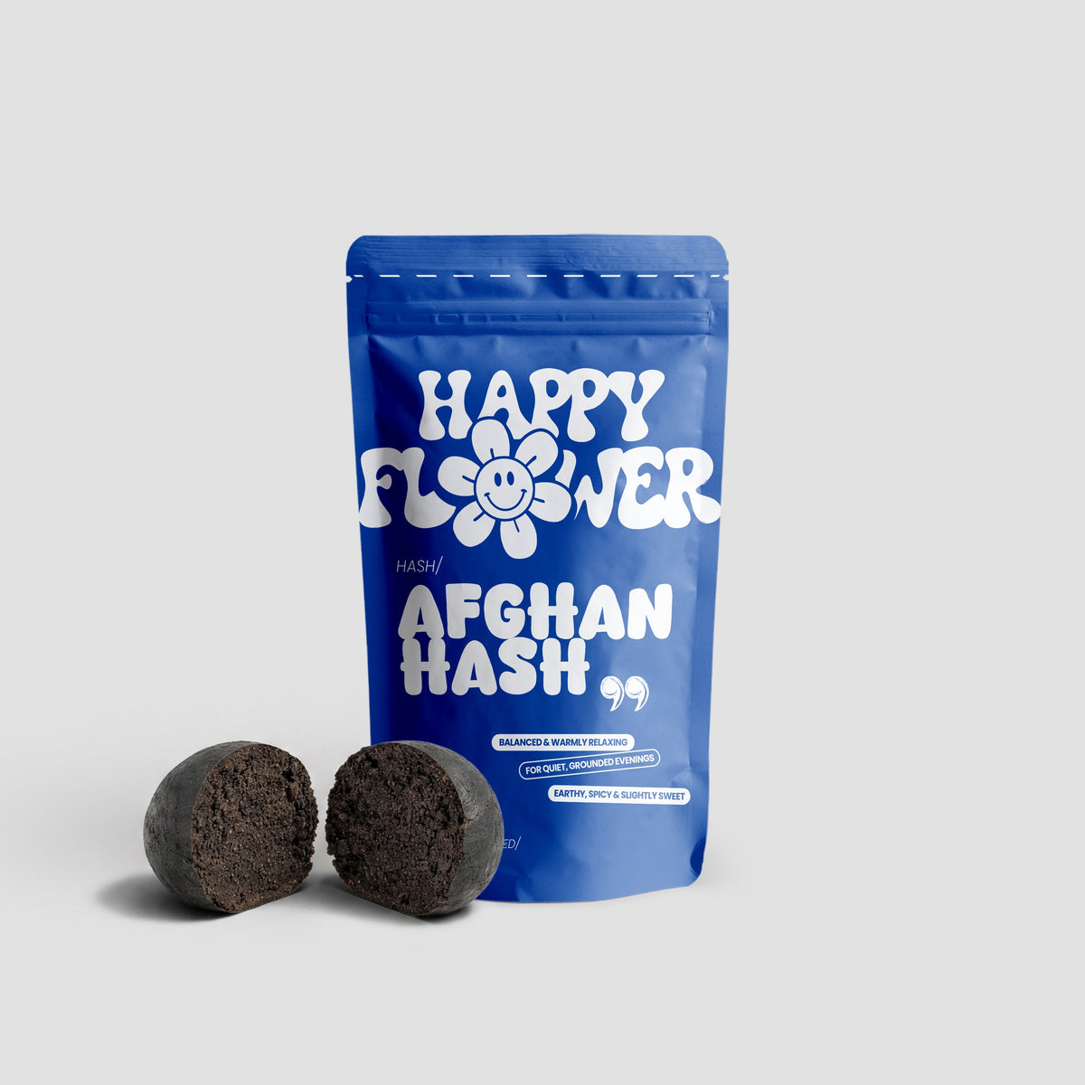 Happy Flower Afghan Hash in blauer Standbeutel-Verpackung mit zwei aufgeschnittenen, dunkelbraunen Hasch-Stücken auf hellem Hintergrund.
